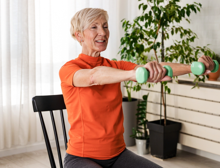 Smiling Senior Woman Doing Gentle Movement Chair Exercises at Home